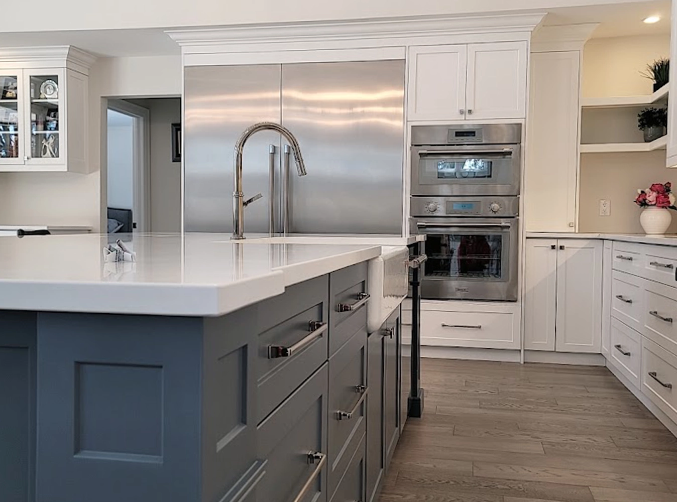 Two-tone kitchen with grey island, white shaker cabinets and stainless appliances