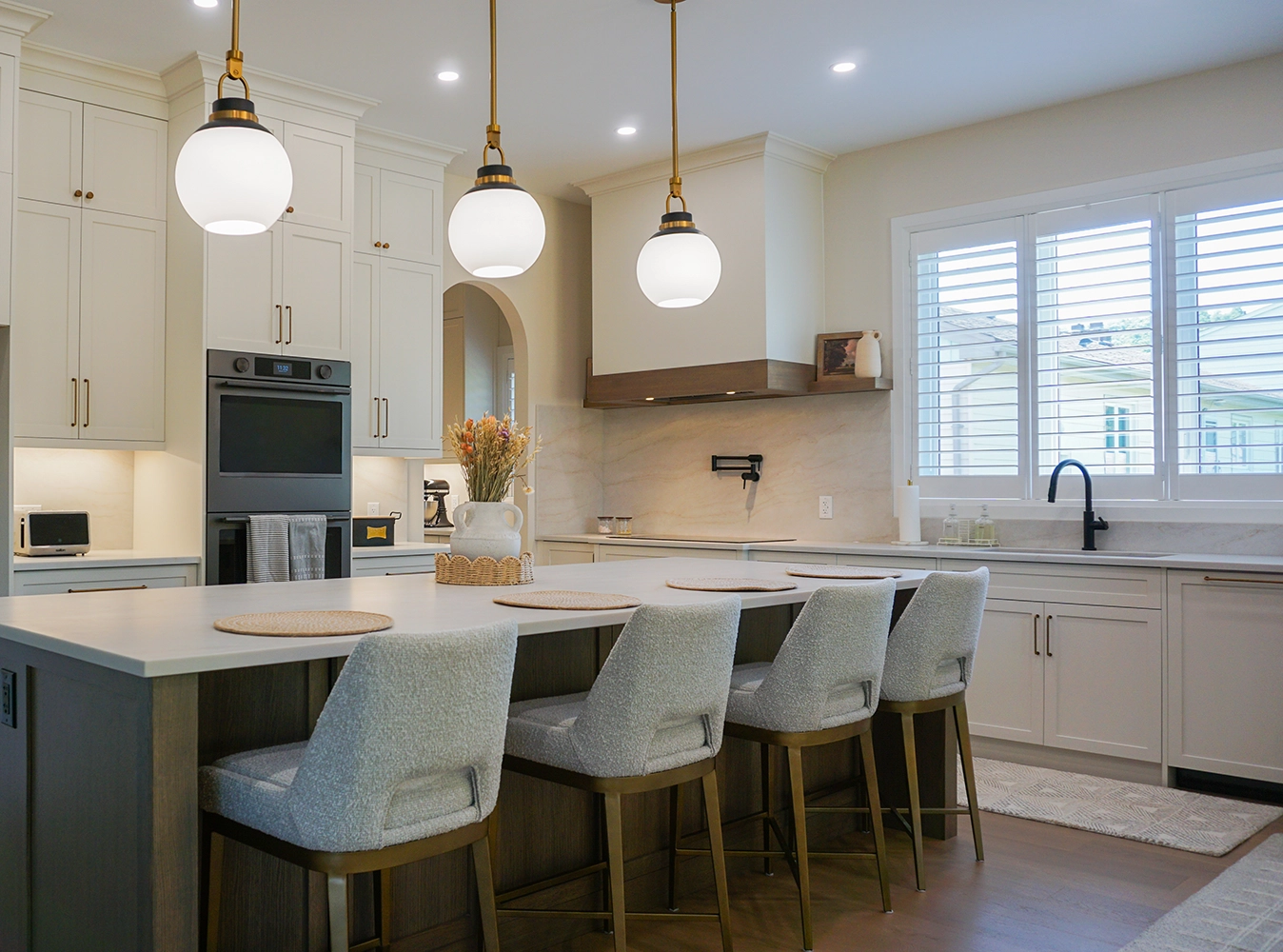Custom kitchen cabinetry with white shaker cabinets and gold pendants